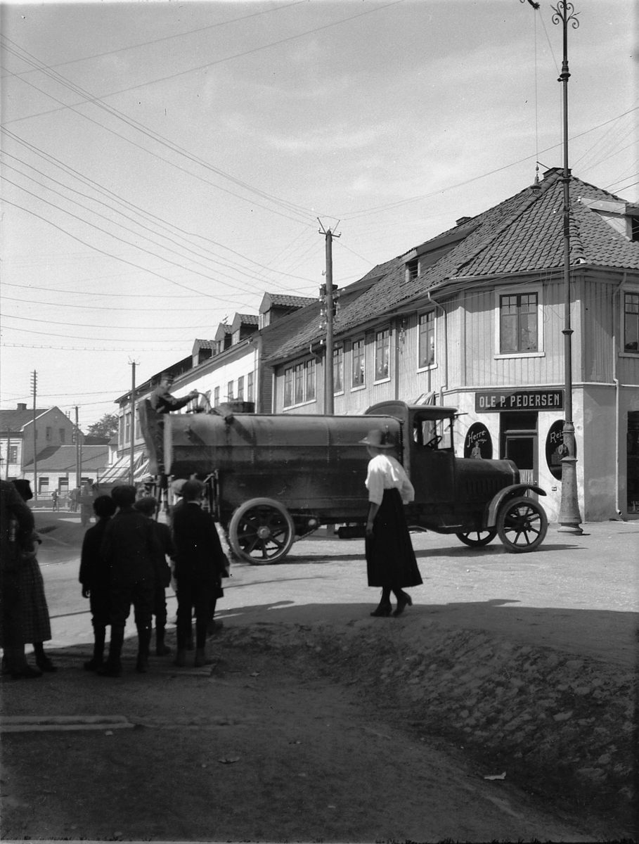 Torggata, Hamar kommunes lastebil, Vomag, D-1168, 1921 modell. vanntank. Ole P. Pedersens forretning til høyre.