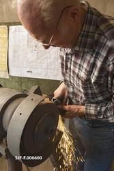 Smeden Oddbjørn Knudsen sliper eggfasene på ei merkeøks han 