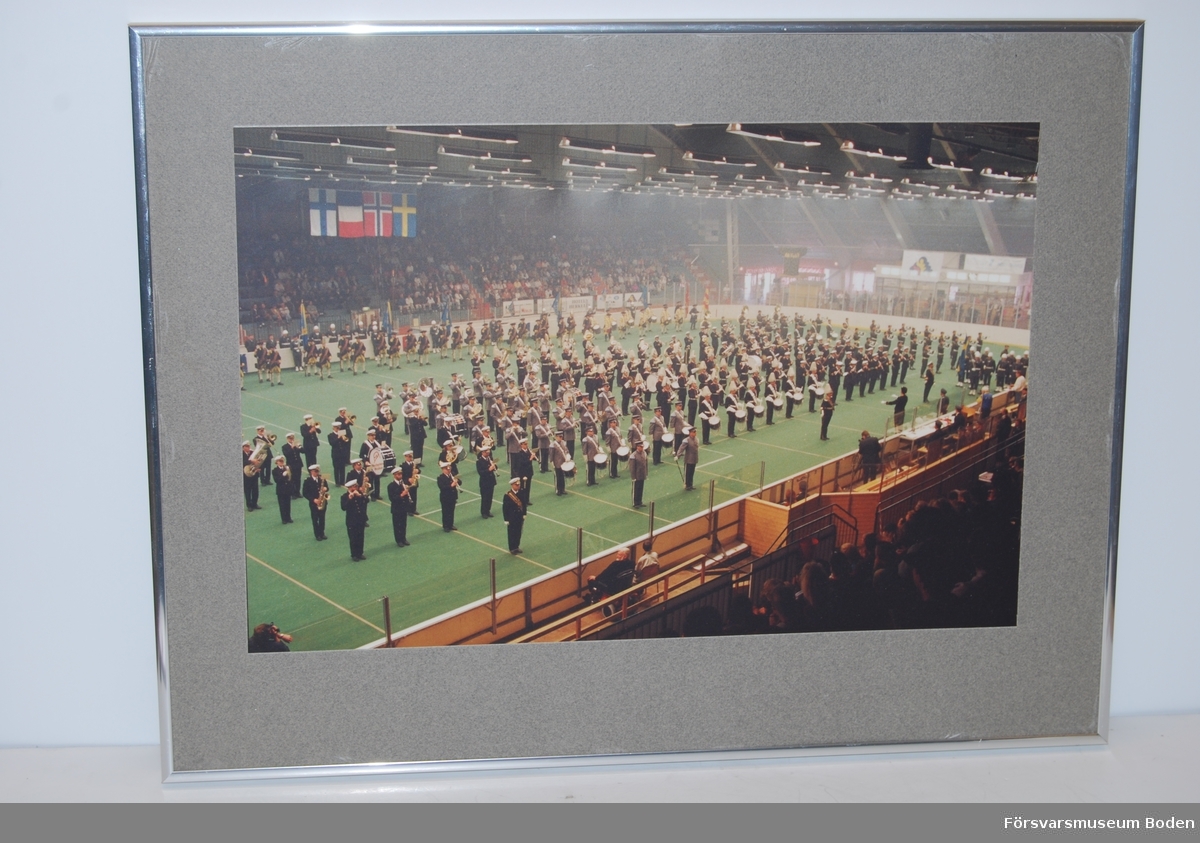 Färgfotografi 55,5 x 42,5 cm, inramat 1992 hos Fotomäster i Boden enligt påskrift på baksidan. Deltagare synes vara musikkårer av olika nationaliteter samt en uppvisningsgrupp med karoliner.