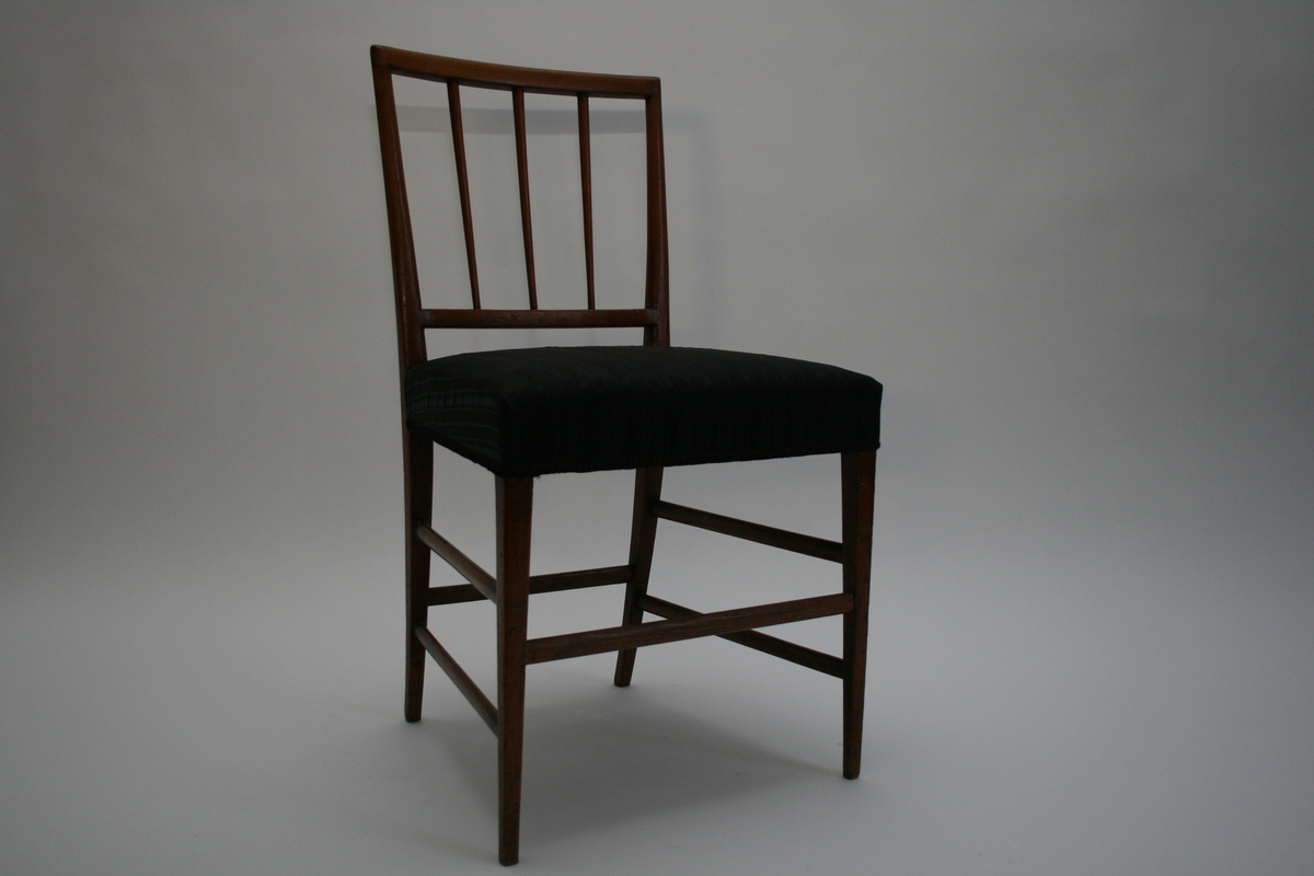Stol av mahogni med hestehårstrekk. Smale, dreide spiler i ryggen og seks ovale sprosser. Under stolen er det originale hjørneavstivere og sekundære hjørneklosser.
Stolene er ikke signert, men identiske stoler signert Jens Brøtterup (1752-1832) er kjent i Danmark.
En av 6 like stoler og tilhørende sofa.