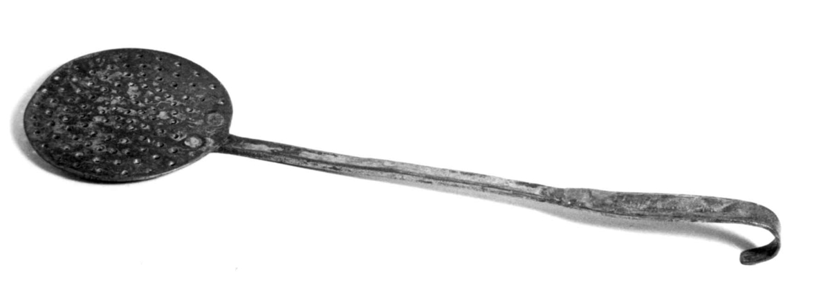 Fiskespade i metall. Sirkulær sil med skaft, enden er formet til en hank.