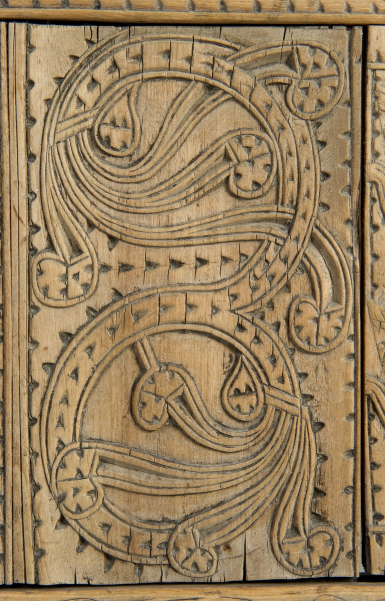 Fire søyler med skåret dyrehode-ornamentikk, sammenføyet med tverrbord og fyllinger. Bunn er åpen foruten to tverrstaver. Hele utsiden er rikt dekorert med utskåret dyr og ranker.