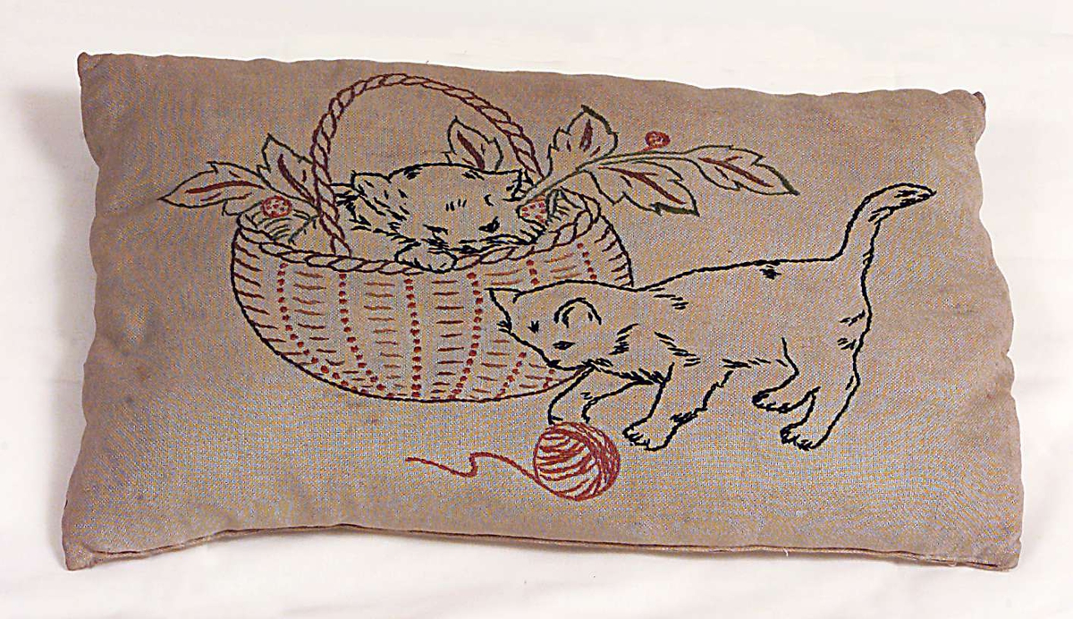To kattunger som leker med en kurv og et garnnøste