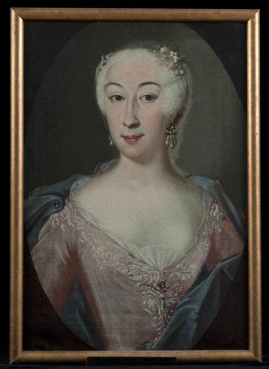 Brystportrett av Anne Cathrine Thaulow (1725-1798) iført utringet rosa kjole og blått draperi. Pudret hår.