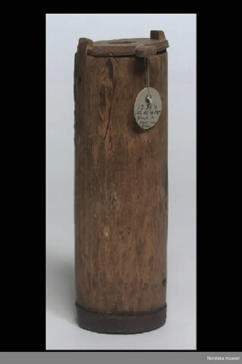 Inventering Sesam 1996-1999:
H 19    Diameter 5,5   (cm)
Smörkärna, "tjennok", leksak, av björk, hög smal modell, lock av furu med runt urtag för stöt. Stöt saknas. Undertill ett bomärke.
Inköpt genom Artur Hazelius för 5 öre.
/Birgitta Martinius 1997