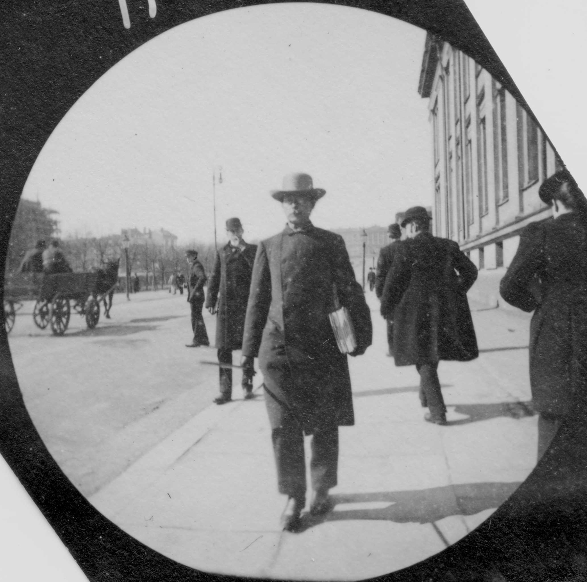 Professor G. O. Sars spaserer langs Karl Johans gate og Universitetet, Oslo. Slottet skimtes.