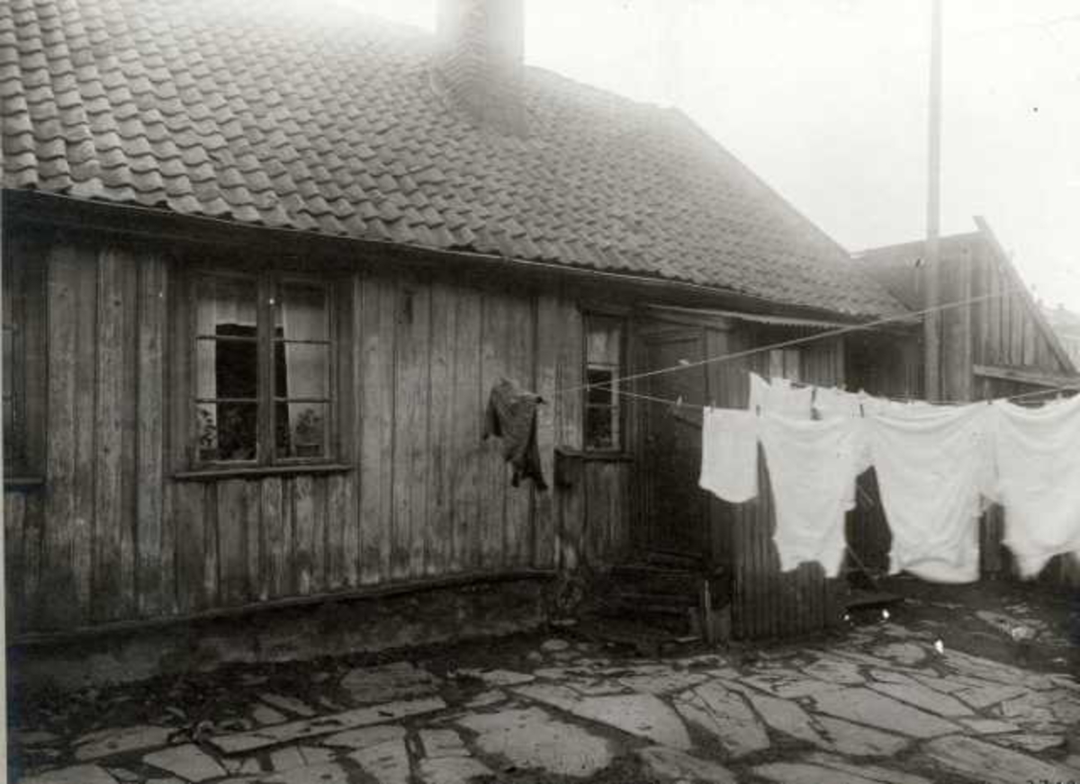 St. Halvards gate 20, Oslo. Lavt trehus, gårdsplass med klesvask.