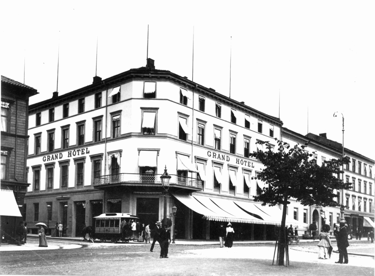 Grand Hotel, Karl Johans gate, Oslo 1885-90. Gatebilde med hotellet, mennesker og hestetrikk.