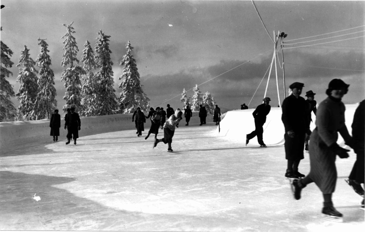 Tryvann skøytebane, Oslo. 1936. Skøyteløpere i sving på isen.