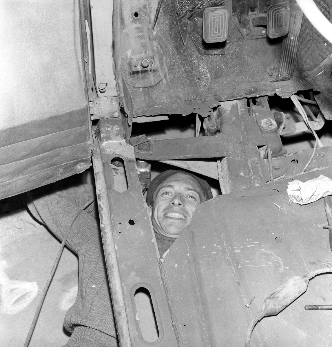 Mann reparerer understellet til bil i et selvbetjenings bilverksted.