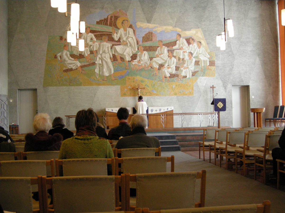 Langfredag i Tonsen kirke, 21.03.2008. Presten står med ryggen til oppe ved alteret som er ganske nakent. Kun dekket med hvit alterduk og et lilla klede. Krusifiks. Lesepulten har også et lilla klede. Veggmaleri.