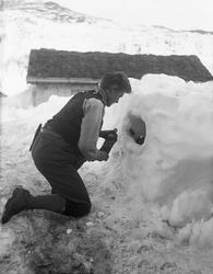 Ung mann, kalt Knold, foran "vinkjelleren", et hull i snøen,