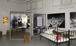 Utstillingsplakater med bilder fra Bastøy skolehjem. Sengene