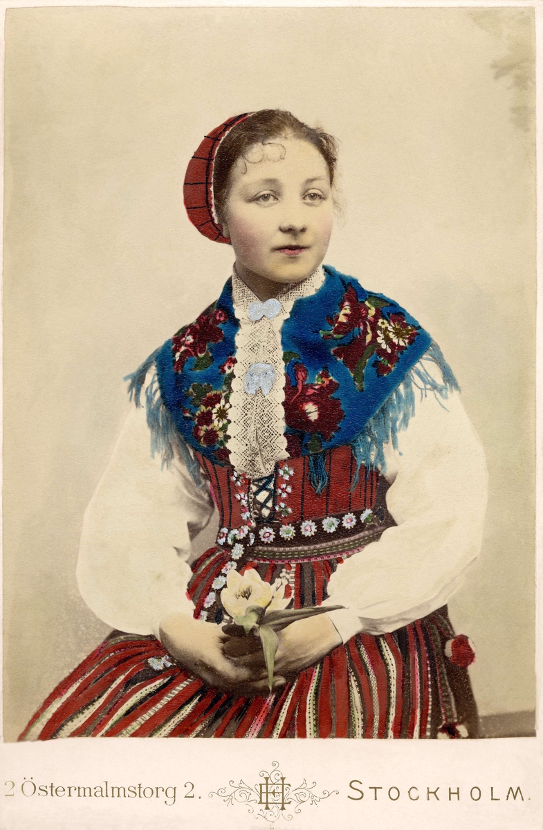 Porträtt på en kvinna klädd i dräkt från Leksand, Dalarna.