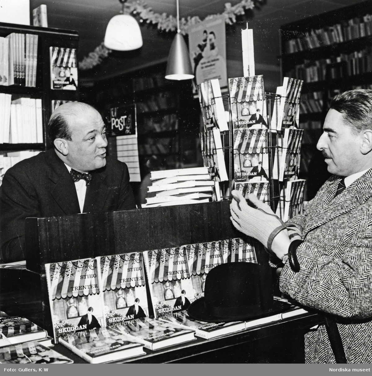 Författaren Stieg Trenter vid en boksignering tillsammans med Runar Karlströmer (1907-77), chefredaktör för tidningen Allers och förlaga till Trenters romankaraktär Vesper Johnson.