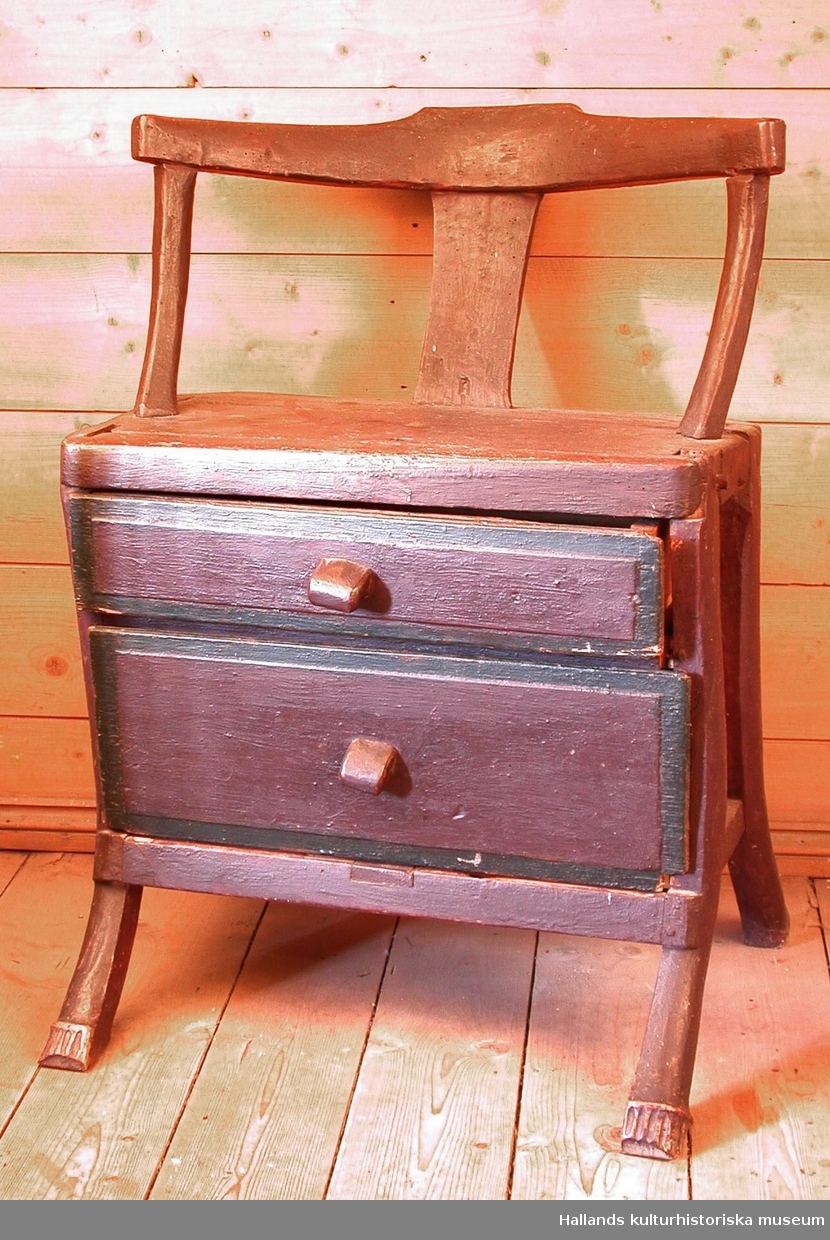 Brunmålad trästol med två lådor med gröna ränder under sitsen.
