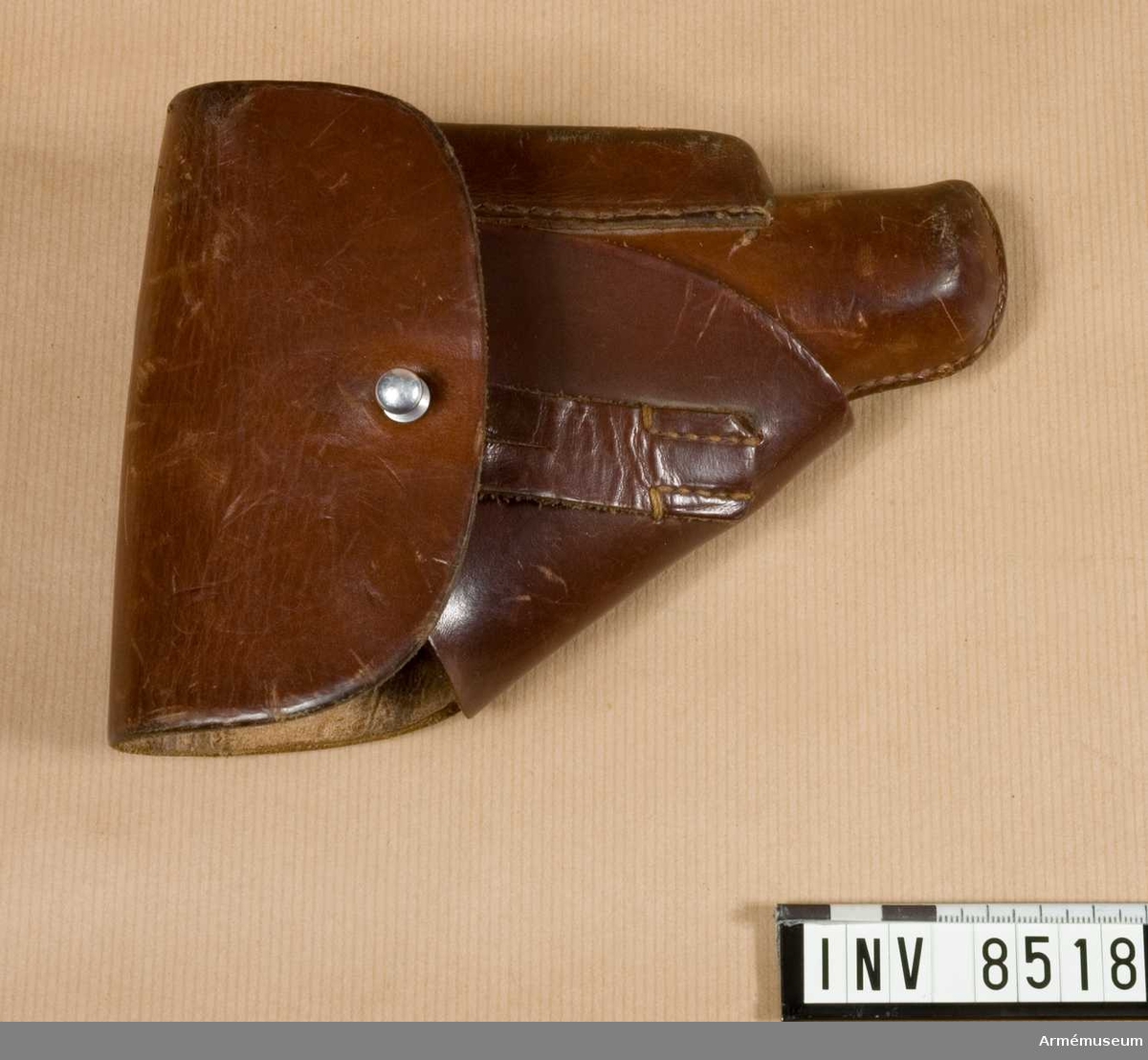 Pistolfodral av läder till halvautomatisk pistol modell HSc, Mauser, Tyskland. Låsknapp av aluminium. Märkt Walther P.P.K. D.R.G.M. (AkAN).

Samhörande nr är 8517-8, pistol, fodral.