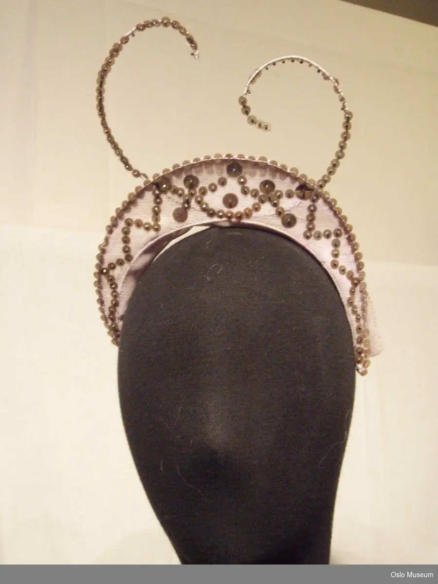 Hodepynt i tiaraform i rosa tyll med paljetter og "følehorn".