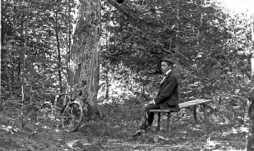 Man och cykel i skogen