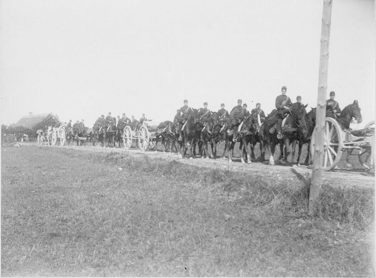 Skånska dragonregementet i kolonn på landsväg i Munka Ljungby. Artillerister till häst och 8,4 cm kanon m/1881.