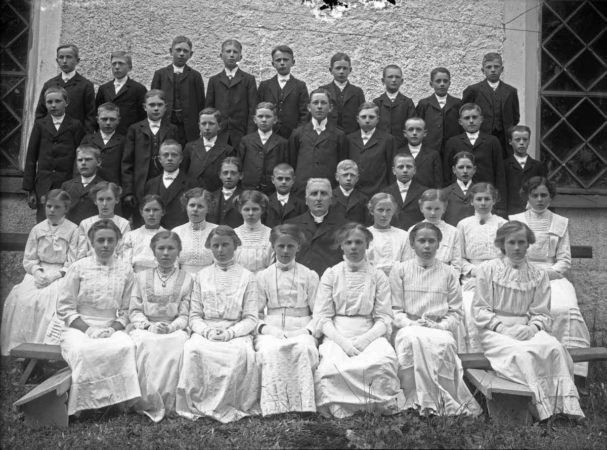 Konfirmandgrupp vid Simtuna kyrka, Uppland. I mitten kyrkoherde August Hylander (1852-1935).