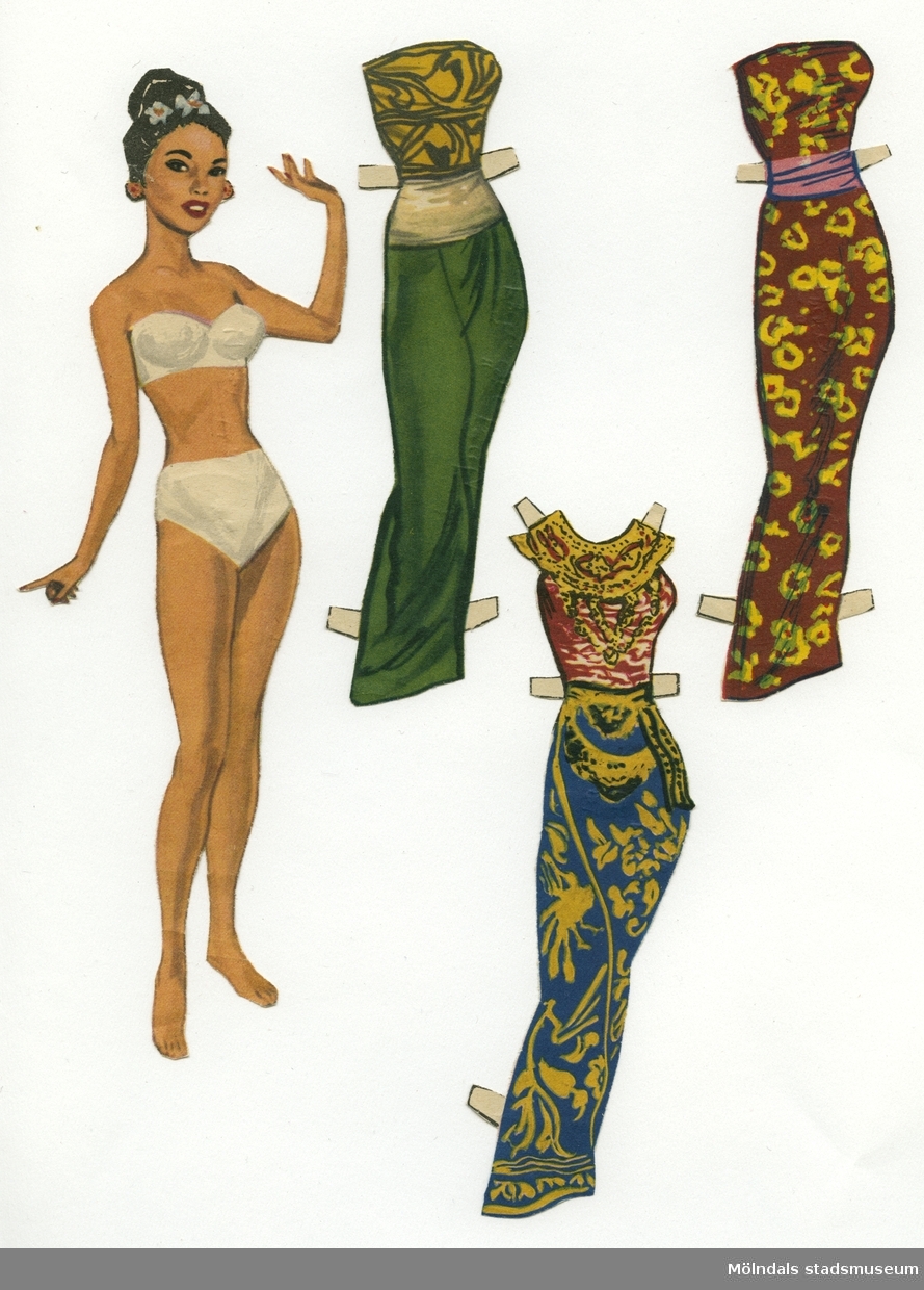 Pappersdocka med kläder, urklippt ur tidning på 1950-talet. Docka och kläder är märkta "Från ön Bali" på baksidan - dockans "nationalitet". Dockan föreställer en ung kvinna med asiatiskt utseende, iklädd vita underkläder. Garderoben består av tre klänningar/saronger, varav en med typisk indonesisk halsbandskrage. Docka och kläder förvaras i en pappmapp, med texten "Senorita" och en flamencodanserska på, tillsammans med andra pappersdockor (MM 04676-04680). Eventuellt har mappen ursprungligen innehållit brevpapper.