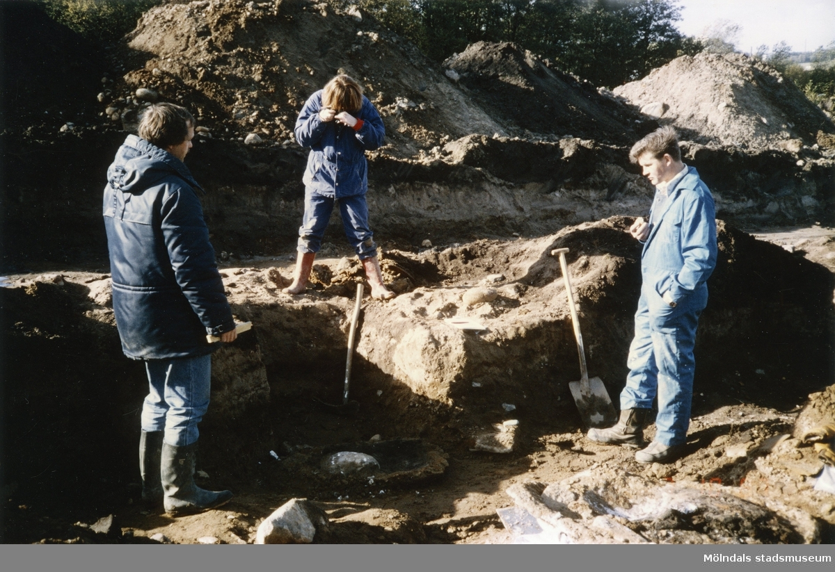 Arkeologisk utgrävning i Balltorp innan industribyggen. Från vänster: arkeolog Bengt Nordkvist, intendent Mari-Louise Olsson, tekniker Sven-Åke Svensson. År 1987.