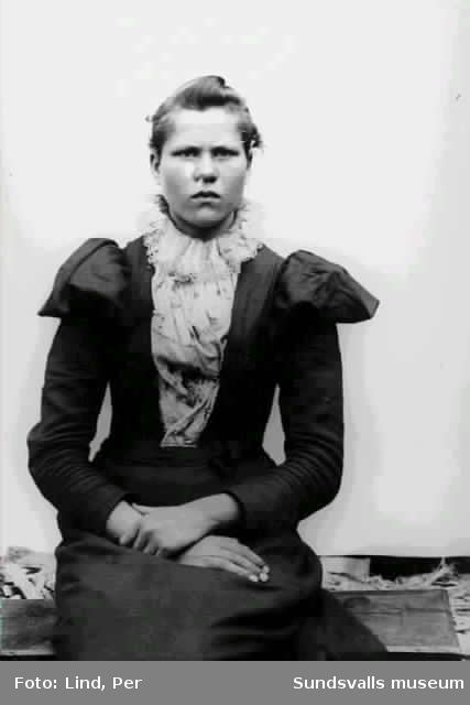 Alby 1898. En kvinna i klänning med puffärmar och virkad spets på halskråset