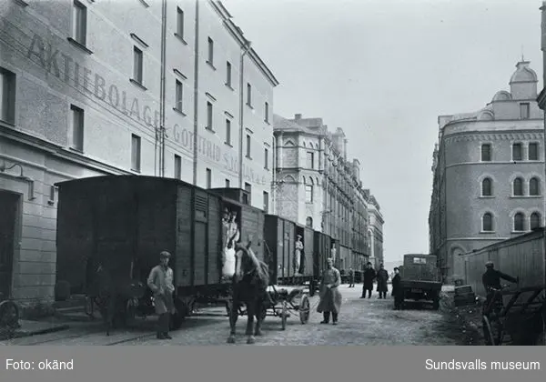 Nya järnvägspåret i Magasinsgatan tas i bruk. Godsvagnar vid  A.B. Gottfrid Sjömans & C:s magasin. Spåret gick längs kajen till Magasinsgatan. Bilden togs den 11 oktober 1928 av Sundsvalls Tidnings fotograf.