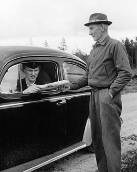 Oscar Hansson, Applahult, tar emot dagens post, maj 1961.
Vikarierande bilåkande lantbrevbäraren Gert Stjernqvist, på
linjen Lönsboda-Duvhult.