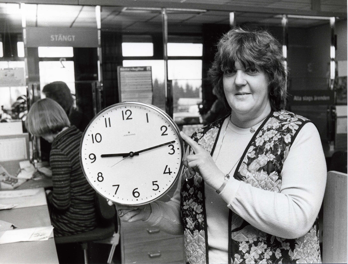 Postmästare Ulla Ölén visar upp den klocka som sitter i lunchrummet på postanstalten Huskvarna 5 i Öxnehaga, och som en dag började gå baklänges istället för framlänges.