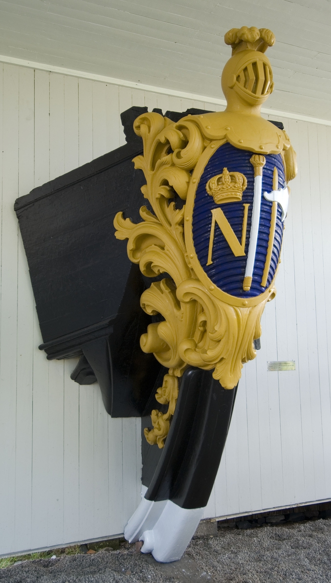 Fregatten Norrköpings galjonsornament
Galjonsbilden utgöres av staden Norrköpings stadsvapen.
Oval blå sköld krönt av gul stridshjälm garnerad med gult akantusornament. Skölden innehåller kungakrönt gult N , vit marskalkstav och stridsklubba med gult skaft och vitt yxblad.