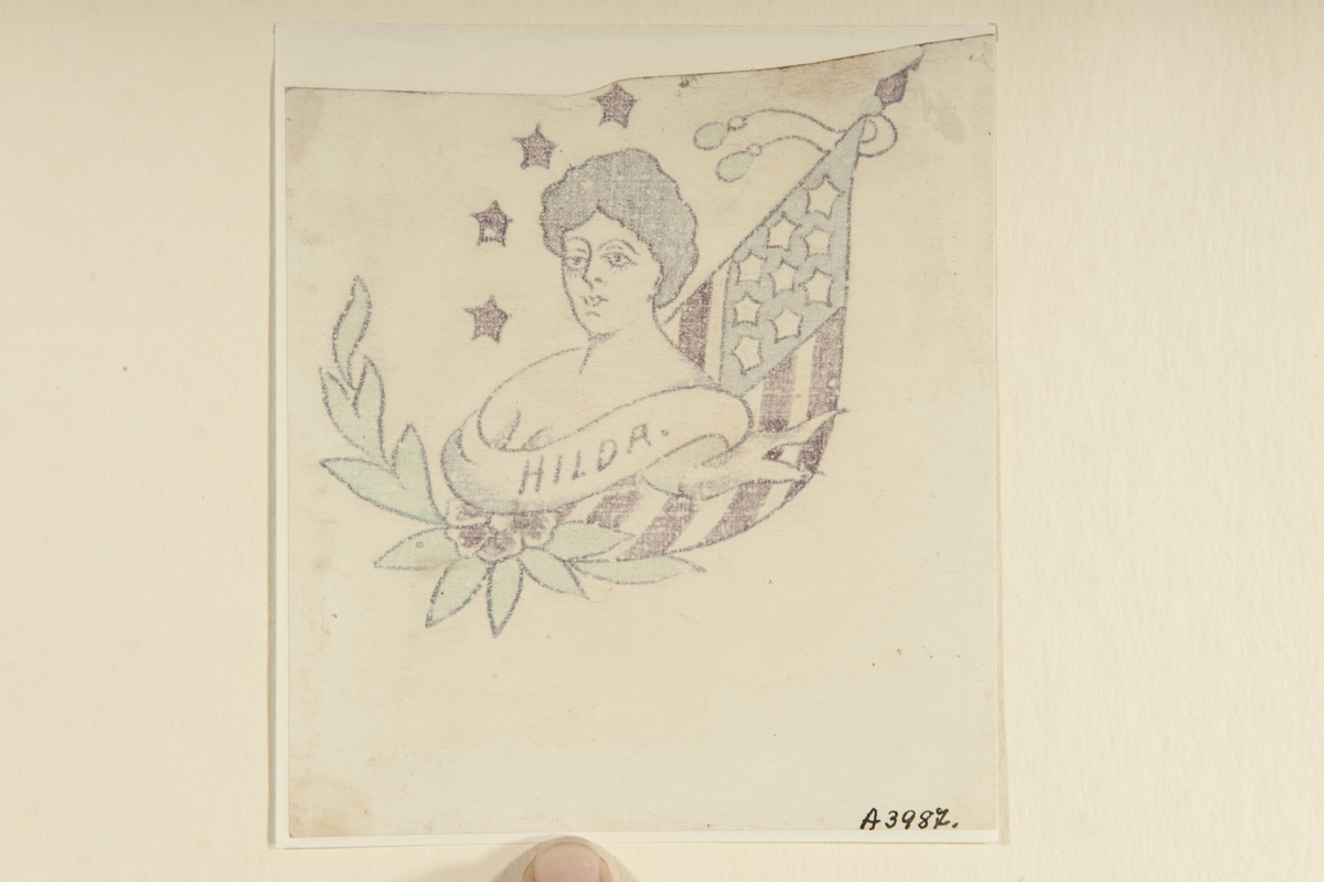 Tatueringsförlaga. Ett kvinnoporträtt med en banderoll med påskriften "HILDA" i förgrunden. I bakgrunden till vänster fyra stjärnor och en blomma, till höger en amerikansk flagga.