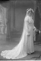 Studioportrett av en brud i helfigur.