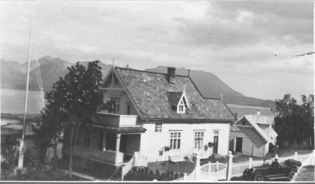 Bertheus Nilsens hus i Hagan, med Grytøya i bakgrunnen.Til høyre i forgrunnen, en bil med sjåfør.
