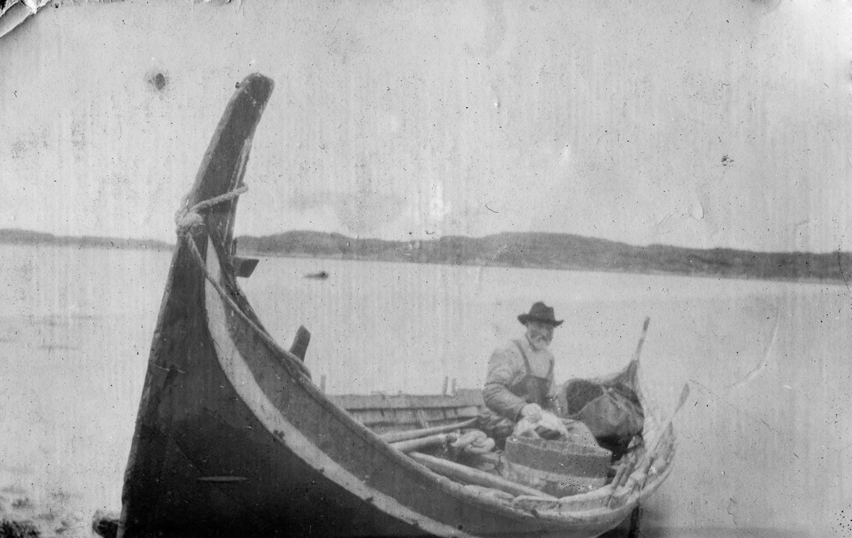 Mann i nordlandsbåt, fotografert på Bjarkøy rundt 1920.