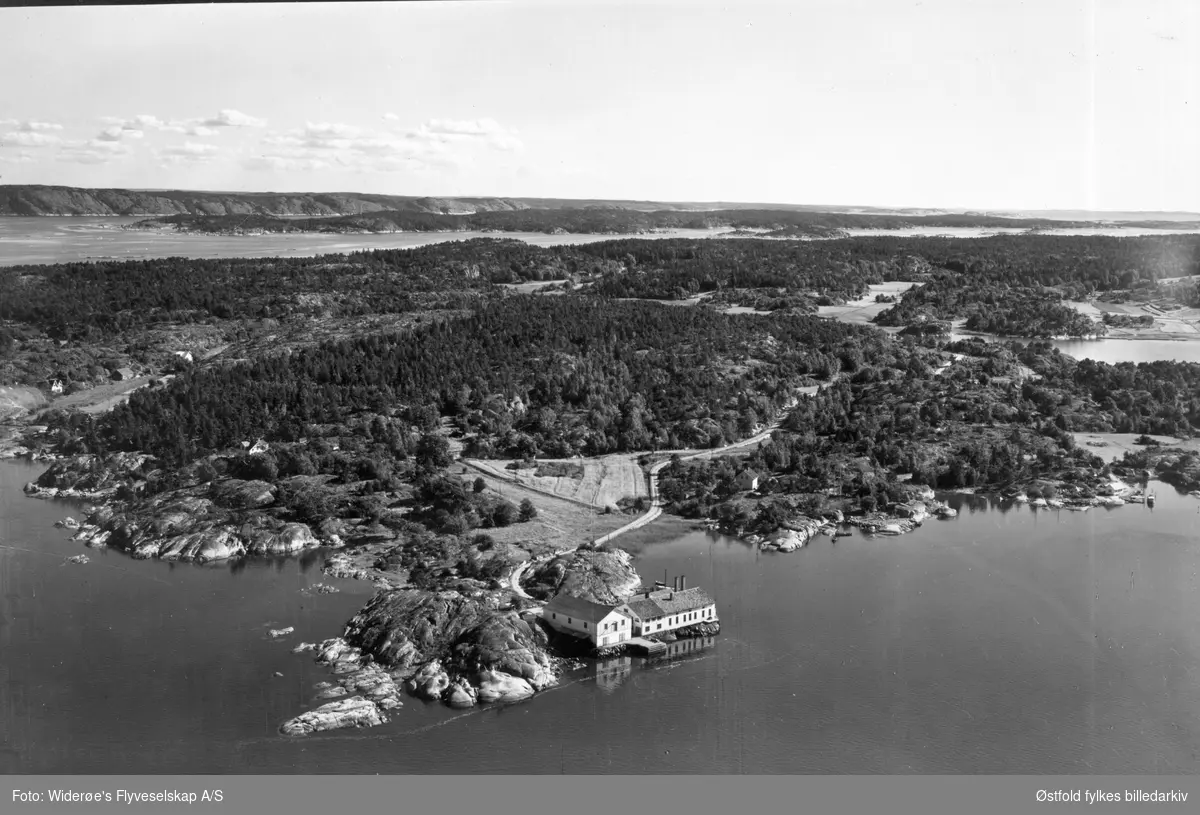 Edholmen på Kirkøy, Hvaler ca. 1950-55. I bakgrunnen Svenskelandet og Sandøyene. I dag er sildefabrikken revet (2022).  Edholmen er idag landfast, tidligere en holme. Postkort.