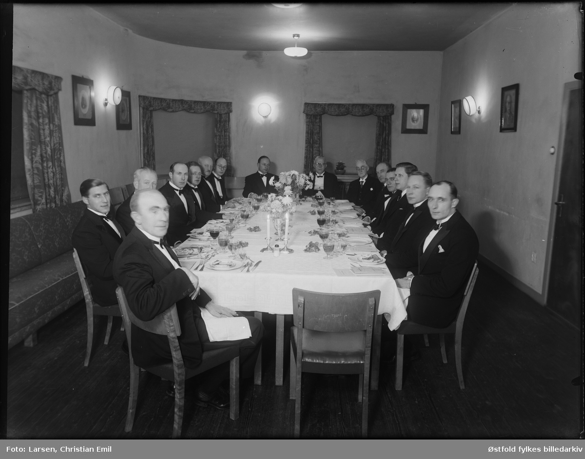 Ukjent gruppe festkledde menn rundt dekket bord, ant Sarpsborg distriktet, 1946.