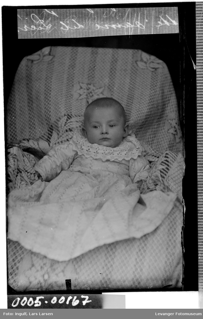 Portrett av spedbarn iført dåpskjole.