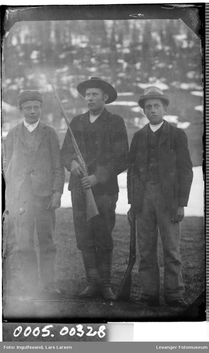 Gruppebilde av tre unge menn med geværer.