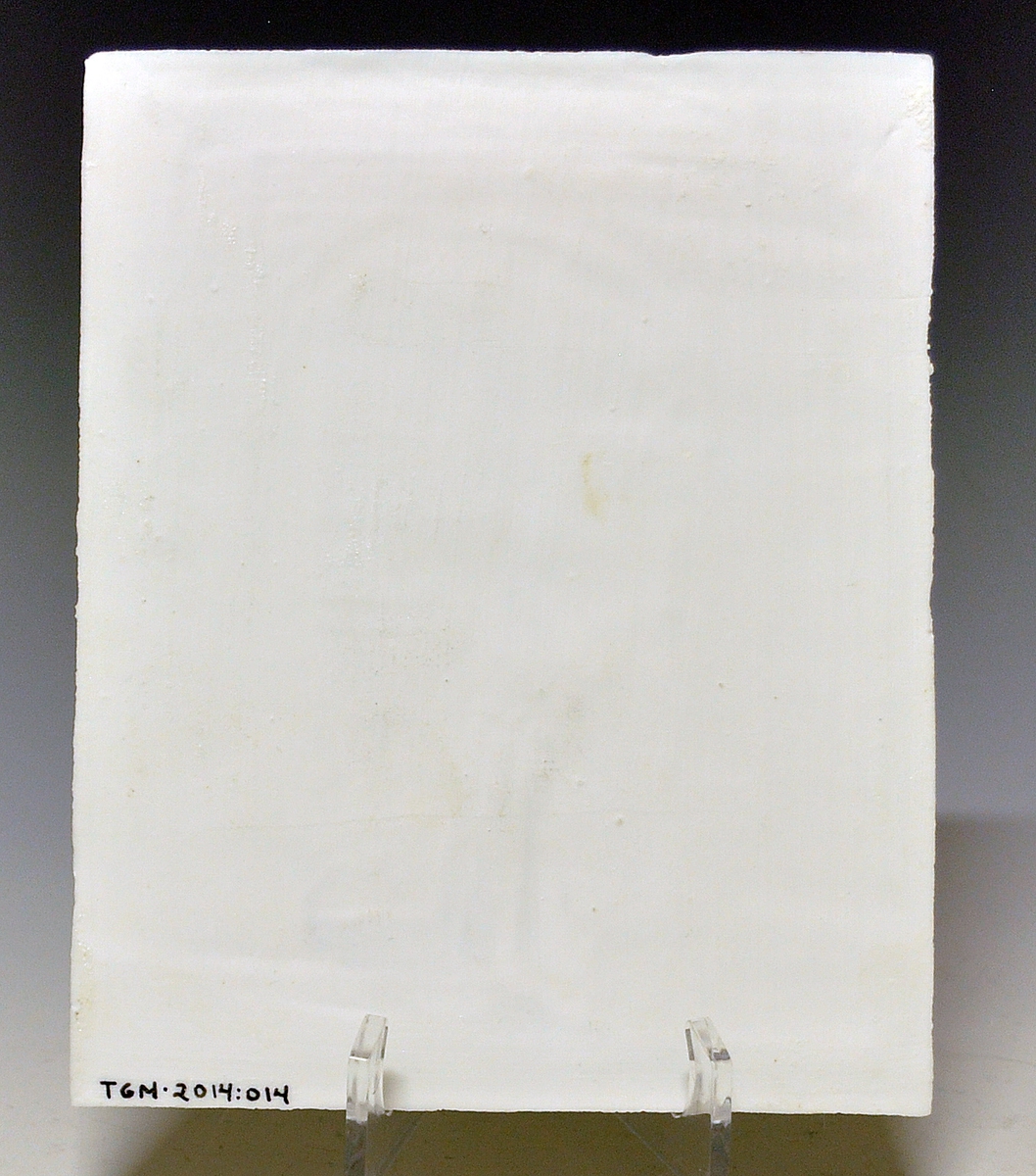 Litofani i porselen. Kalt lysbillede i priskuranten fra 1888. Motivet preget inn som relieff. Uglasert. Motiv: Figur i døråpning. Utsikt mot bygning og landskap.
Ustemplet.
