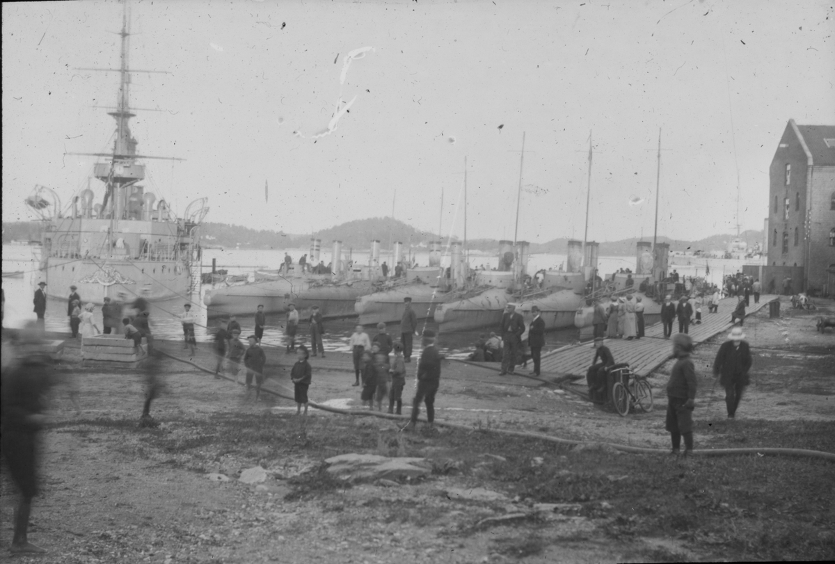 Marinebesøk 1918 i Kragerø. Ser mange mennesker og marinebåter. Trikotasjen til høyre i bildet