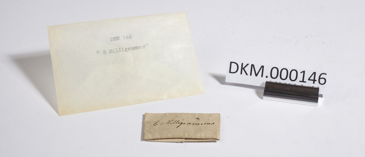 Papir brettet til en konvolutt som inneholder flere små metallbiter.