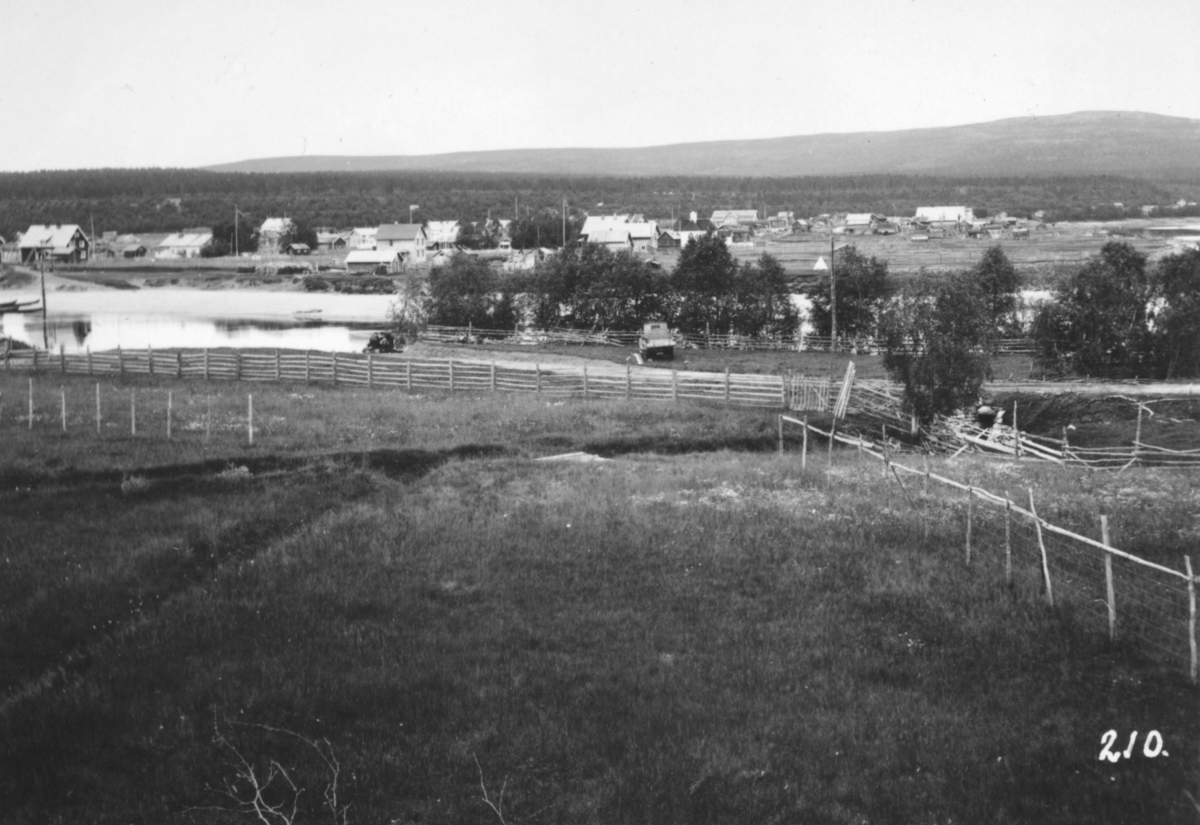 Jordbrukskomiteen på Stortinget foretok en reise til Finnmark i 1935. Kleppe var med, og ga bildene sine fra denne turen til fylkesmann Gabrielsen etter krigen. Her har Kleppe fotografertet Karasjok om kvelden. I forgrunnen inngjerte gressmarker, elven, hus og en lastebil.