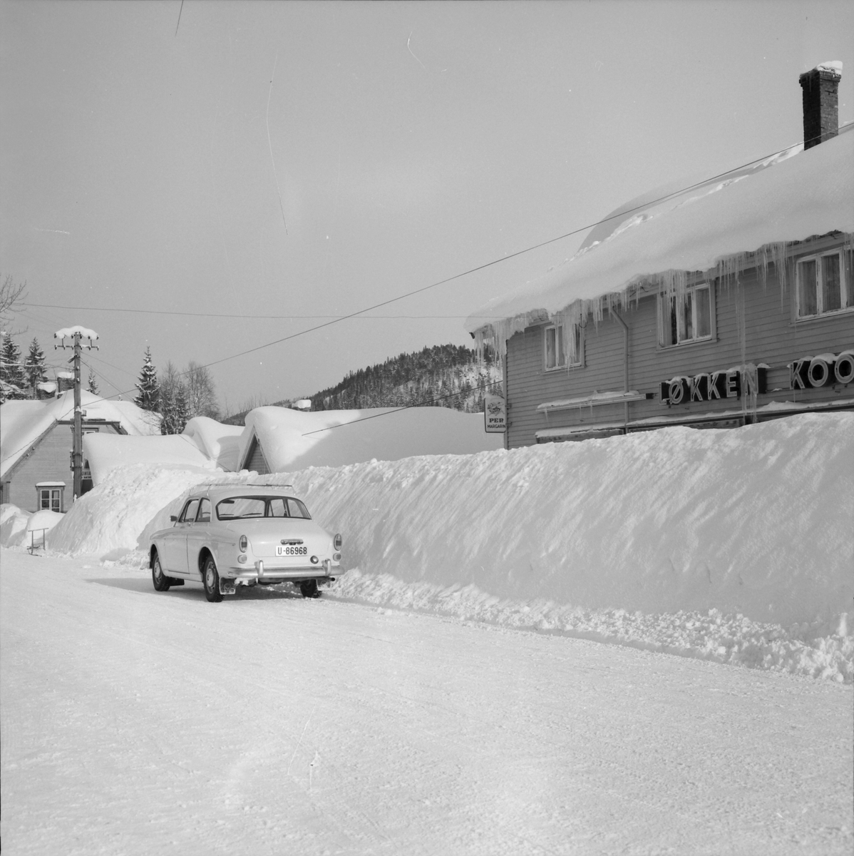 Vinterbilde av hovedveien og Kooperativet i Løkken sentrum.