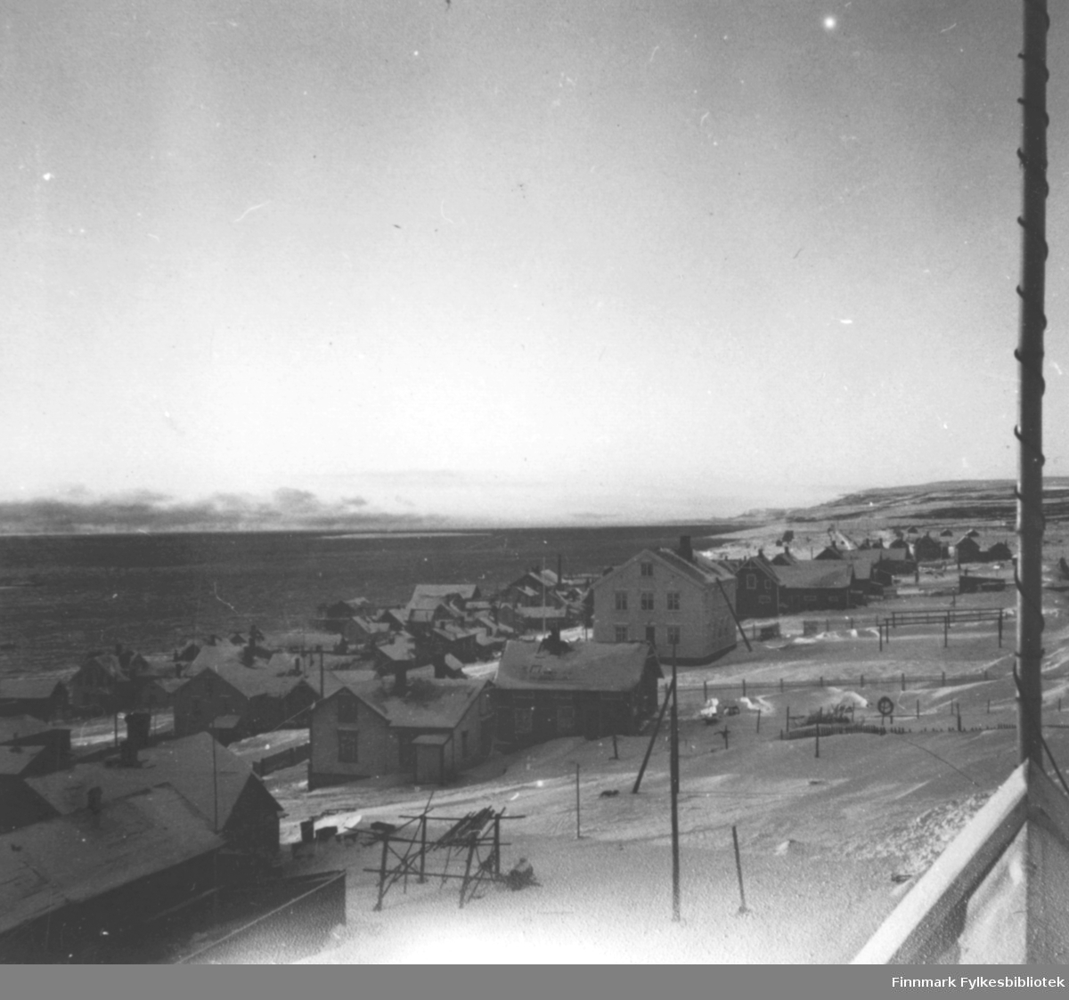 Utsikt mot Indrebyen i Vadsø med lille Vadsøya i bakgrunnen og førkrigsbebyggelse i forkant.