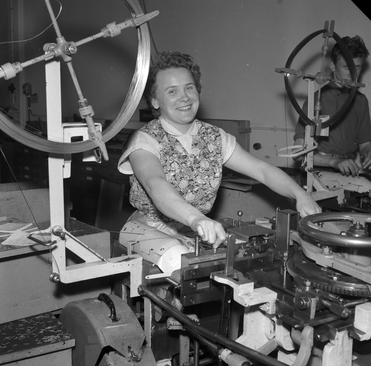 En kvinna sitter vid en maskin på Huskvarna Borstfabrik och arbetar.