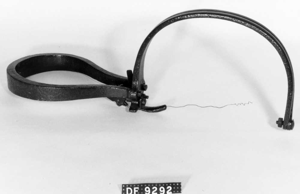 To bøyler som slås sammen av en fjær. Messingtråd festet til utløsermekanismen.