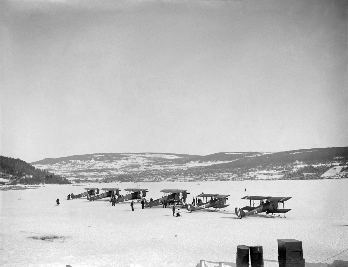 Fly. Hærens fly.  Sju Fokker og Tiger Moth. Blant annet fly 169 og 179. Mjøsisen. Lillehammer by i bakgrunnen.