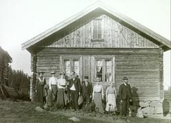 Menneskegruppe fotografert ved hytte